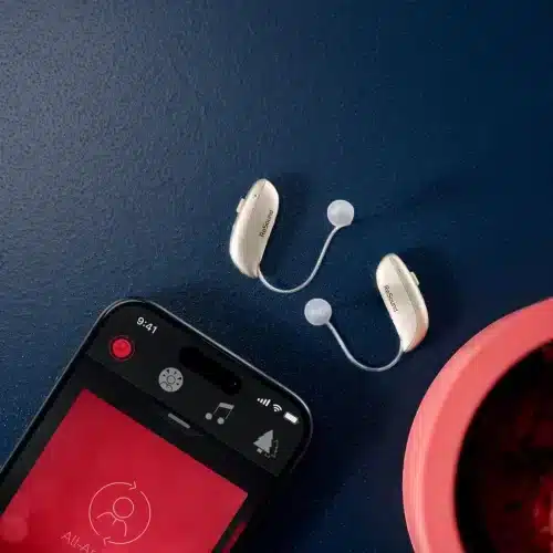 Deux appareils auditifs ReSound Vivia VI 960 S DRWC posés près d’un smartphone affichant l’app ReSound Smart 3D.